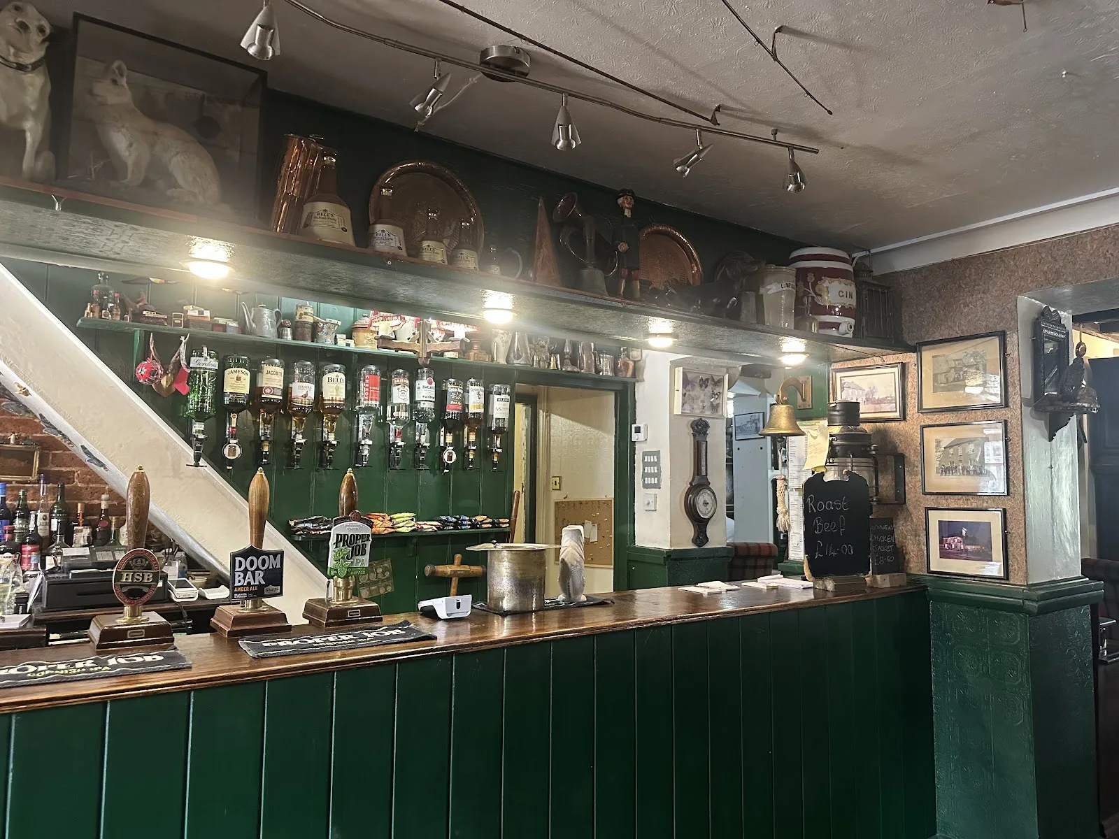 The green panelled bar at the Yew Tree Inn with hand pumps for HSB, Doom Bar and Proper Job, optics and copper on the shelf above